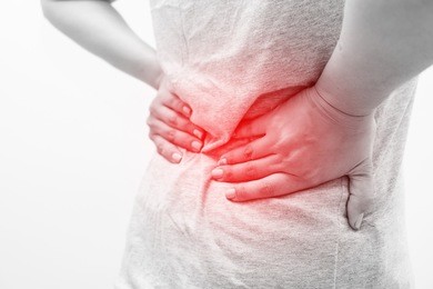 close up hands touching back pain or lower back pain with red highlights. fat woman back ache and feeling her back tired after working. disease of overweight women or office syndrome concept