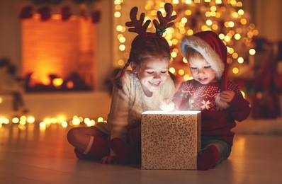 merry christmas!happy children with magic gift at home near  christmas tree and fireplace