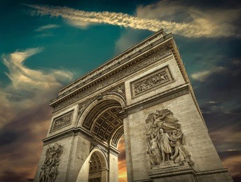 arc de triomphe in paris under sky with clouds. one of symbols of france and one of the most popular tourist places in the world.