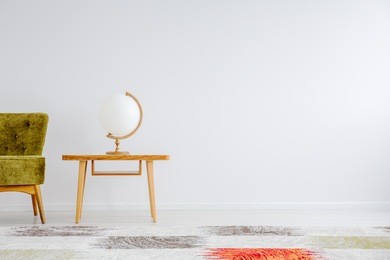 wooden globe shaped lamp standing on small table in white room with copy space