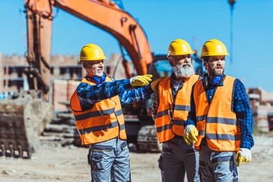 foreman showing builders something at the construction site by pointing his hand 