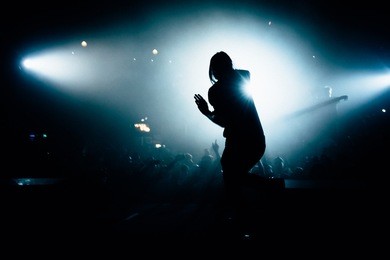 man singing in front of the stage crowd. singer doing his best at the concert.