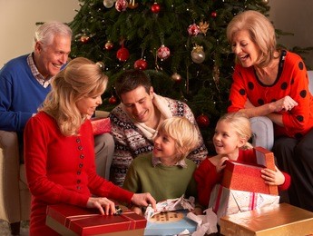 three generation family opening christmas gifts at home