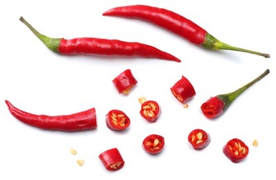 sliced red hot chili peppers isolated on white background top view