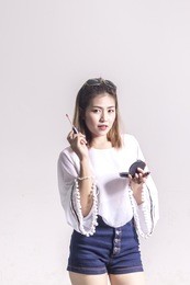 beautiful asian woman with makeup brush