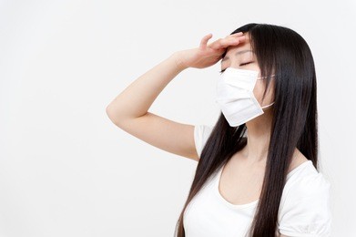 beautiful asian woman with a headache