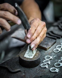 thai jeweler, handles the jewelry and precious stones in the workshop, the process of jewelry making ,close-up