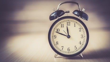 vintage background with retro alarm clock on table