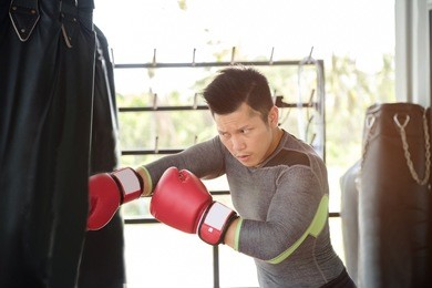 asian handsome fitness man who has perfect body by boxing with boxing gloves at gym, healthy man do workout at gym, healthy sport concept