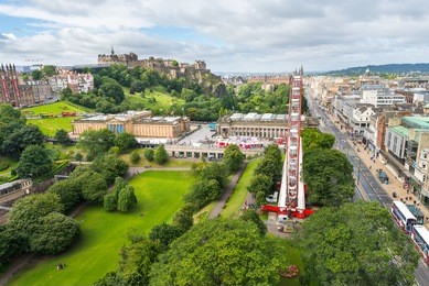 edinburgh castle, princes street gardens, and the edinburgh wheel as seen from top of the scot monument on a sunny day, in edinburgh, scotland, uk