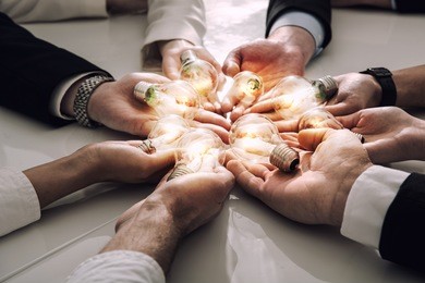 teamwork and brainstorming concept with businessmen that share an idea with a lamp. concept of startup