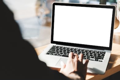 young man working on his laptop with blank copy space screen for your advertising text message in office, back view of business man hands busy using laptop at office desk
