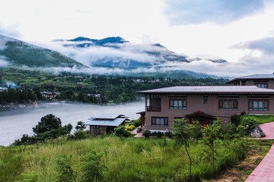 bhutanese village near the river on a foggy day at punakha, bhutan.