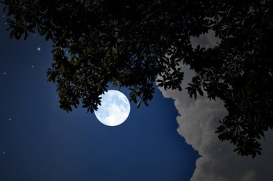 bright moon and white clouds in blue night sky