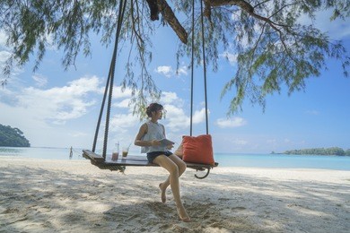 asian woman on relax time on the beautiful beach and swings