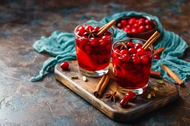 two glasses with a hot drink of cranberries and apples with spices, mulled wine, punch or grog.