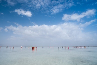 a busy day at chaka salt lake; touted as the mirror of the sky of china, tourists moving around in the salt lake disturbed the claim water, reflection of the sky can hardly been seen