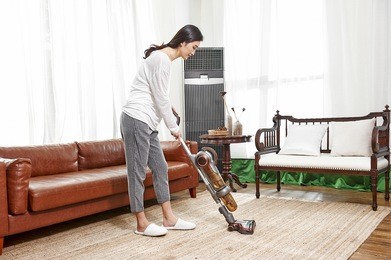 young asian woman with vacuum cleaner cleaning