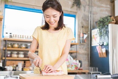 young attractive asian woman cooks in a kitchen,chicken