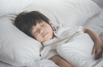 cute asian child sleeping on white bed