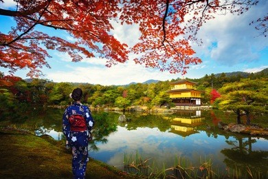 women in traditional japanese kimonos looking at kinkakuji temple in kyoto japan