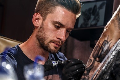 professional tattoo artist at work in a tattoo studio.