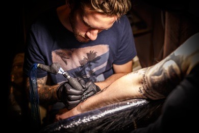 professional tattoo artist at work in a tattoo studio.