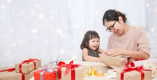 asian little girl help her mother wrapping gift box, celebration holiday christmas mother'?s day concept.