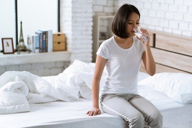 asian woman drinks water after waking up in the morning.