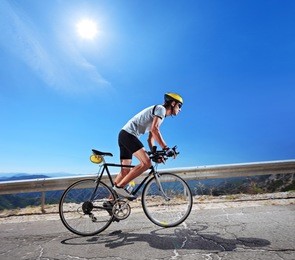 cyclist riding a bicycle in macedonia with a sun in the background
