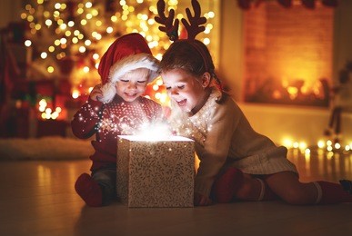 merry christmas!happy children with magic gift at home near  christmas tree and fireplace