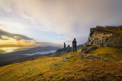 woman standing at the old man of storr on the isle of skye, scotland. 