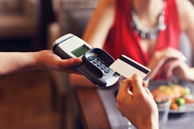 picture showing people paying in restaurant by credit card reader
