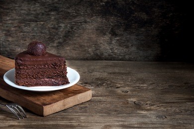 piece of chocolate cake on white plate on wooden background. homemade chocolate cake.