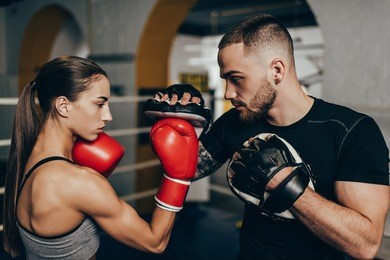 side view of young male and female boxers training on boxing ring 