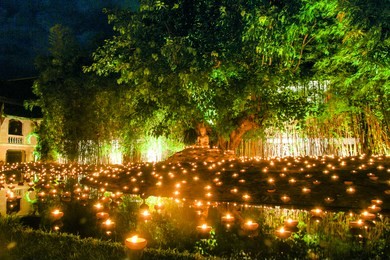  light candles and pray to buddha statue in phan tao temple , chiang mai ,thailand. slow shutter speed.