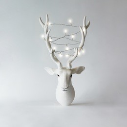 white christmas reindeer head with antlers with christmas lights. new year concept.