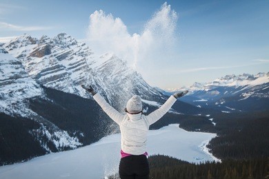 detail of female outdoor enthusiast throwing, spreading snow in shape of heart at viewpoint above peyto lake, alberta, canada, banff national park. winter outdoor activities in rockies, love, joy.
