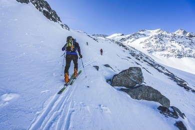 ski touring in high alpine landscape. ascent and descent to a summit of an alpine peak. snow and winter activities, skitouring in mountains.