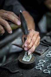 thai jeweler, handles the jewelry and precious stones in the workshop, the process of jewelry making ,close-up