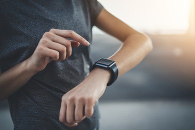 closeup of female hands using modern smart watch with touchscreen, sportive woman checking her progress on modern device after intensive workout, flare light