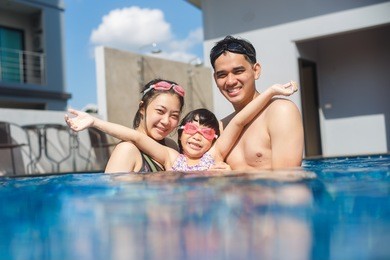 happy asian family playing in swimming pool,holiday
