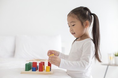 girl playing toy with attractive smiling at home. happy family concept.