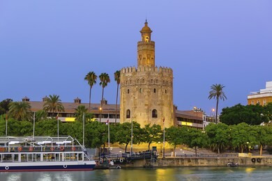 golden tower (torre del oro) at sunset from the other side of the guadalquivir river, seville (andalusia), spain.