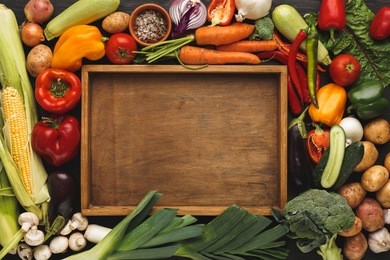 fresh organic vegetables and wooden box with copy space background. healthy natural food. tomato, leek, carrot, pepper, potato and other cooking ingredients top view