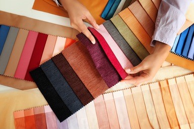 young woman with fabric samples for curtains at table