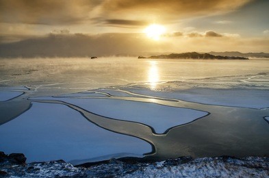 ice floes floating on the fog water in the lake baikal. sunset