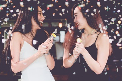 celebration party group of two asian young  women people holding confetti happy and funny concept. in 2018 new year holiday.