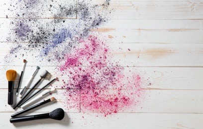 wallpaper for professional makeup and fashion accessories with blush and eyeshadow brushes with smashed colorful pigments, white wooden background, copy space, above view