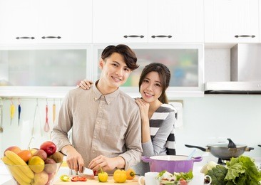 happy asian couple cooking in the kitchen